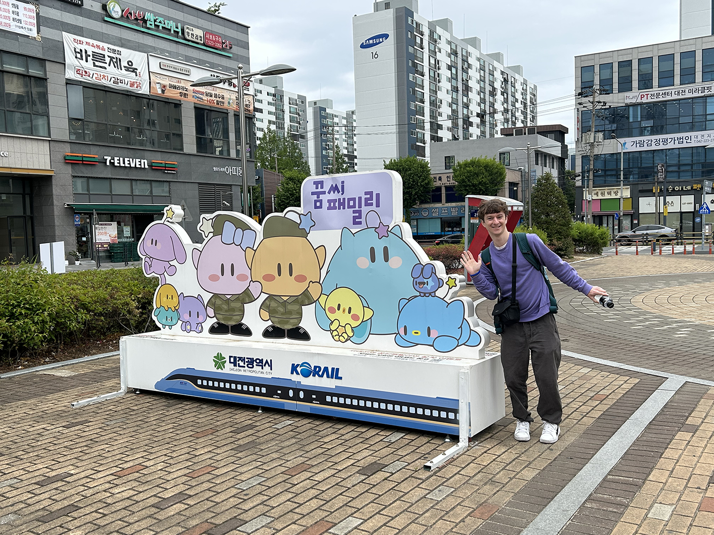 Camden in front of the Daejeon Mascot family at the station