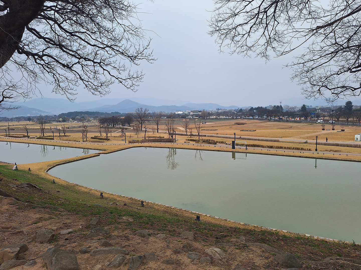 Landscape of the Wolseong Fortress from top of hill with ponds in foreground and lawns in the background