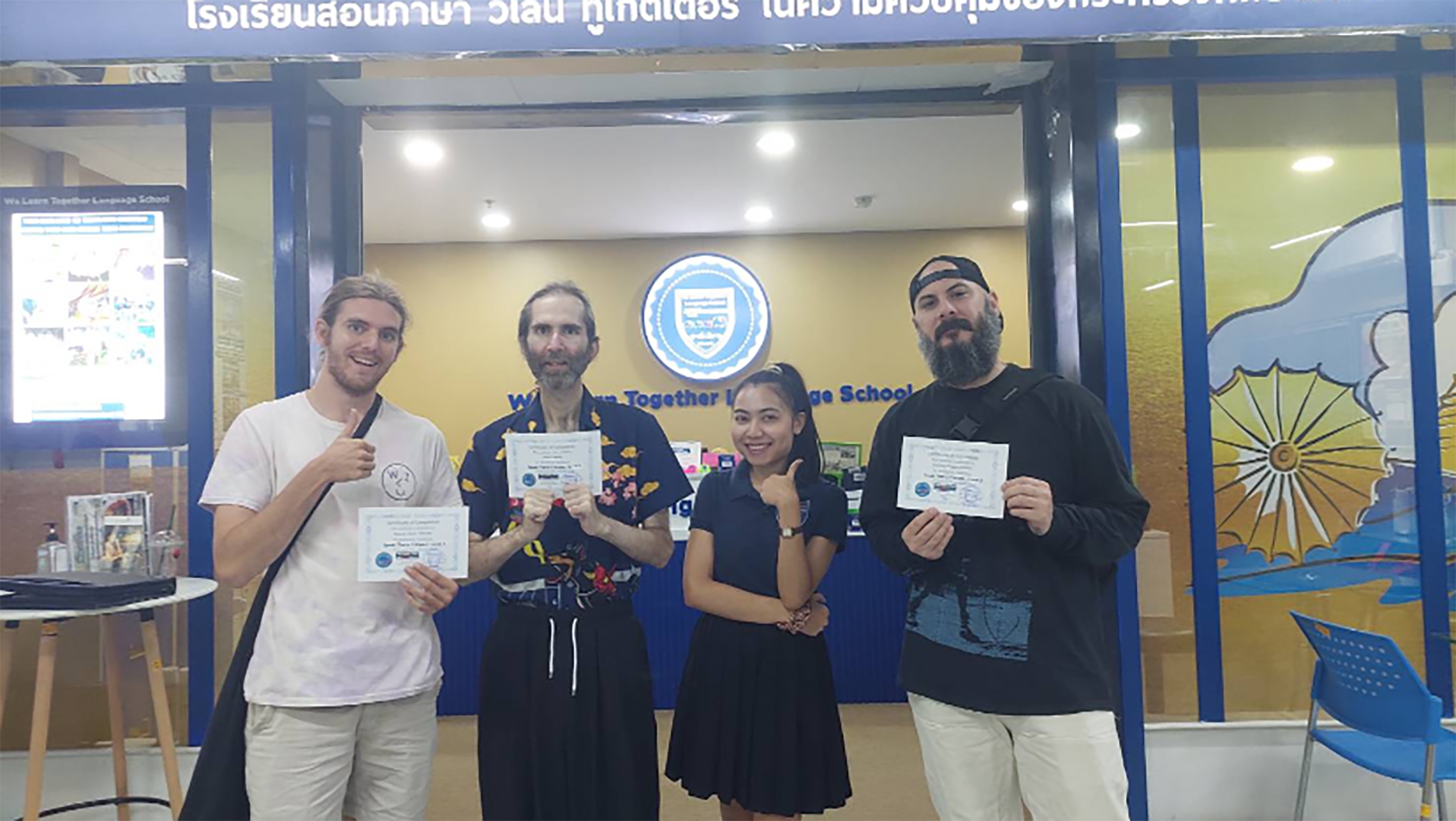 Same and his classmates posing with their education visa documents in front of their school