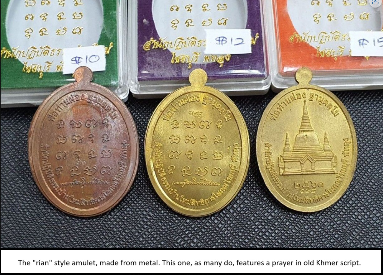 The 'rian' style amulet, made from metal. This one, as many do, features a prayer in old Khmer script.